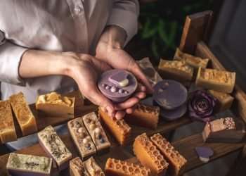 A woman master soap maker holds handmade lavender soap in her hands. Eco-friendly natural craft cosmetics production